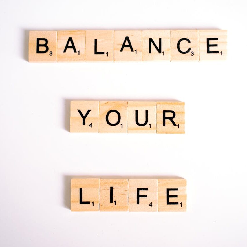Inspirational message 'Balance Your Life' made with Scrabble tiles on a white background.